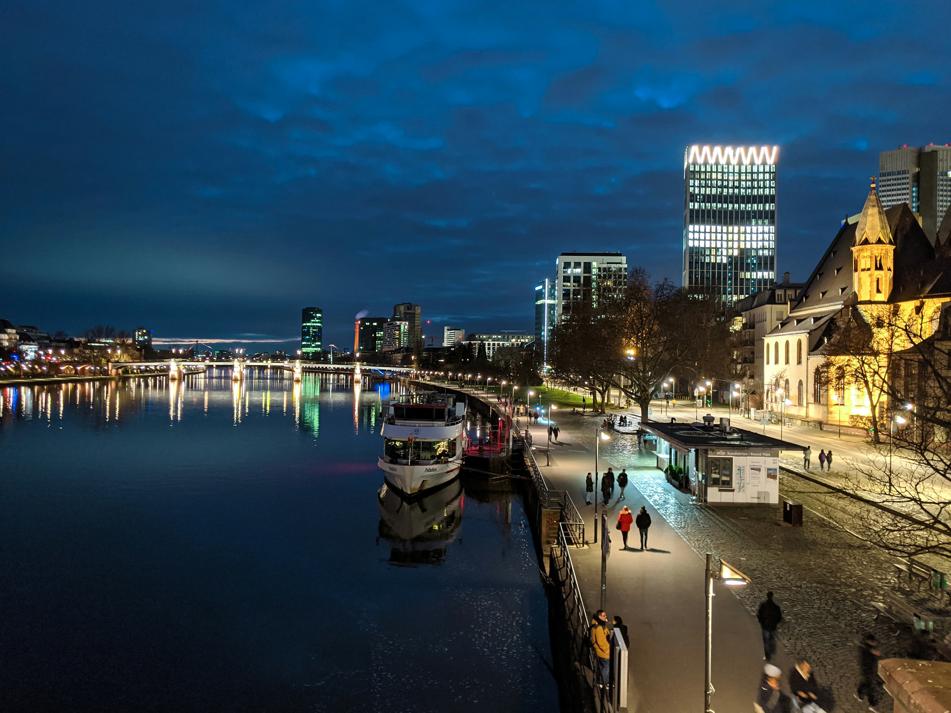 white and black boat on water near city buildings during night time